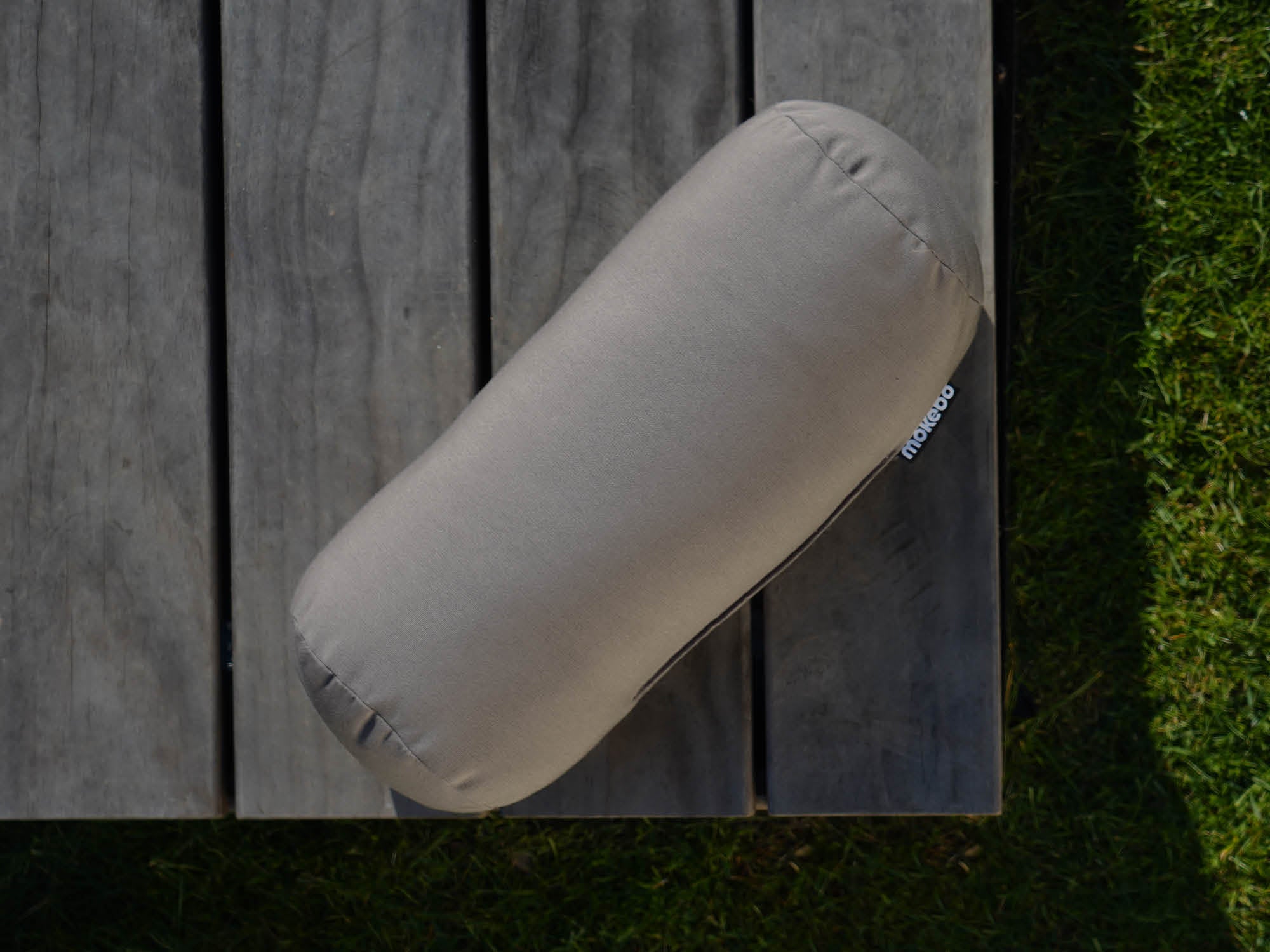 Outdoor Kissen Nackenrolle 'Das Träumchen' in taupe auf Holzterrasse 