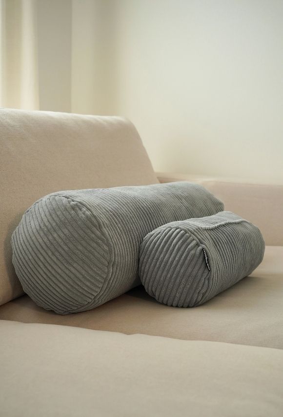 Kissen Nackenrollen Cord grau groß und klein auf einem Sofa 