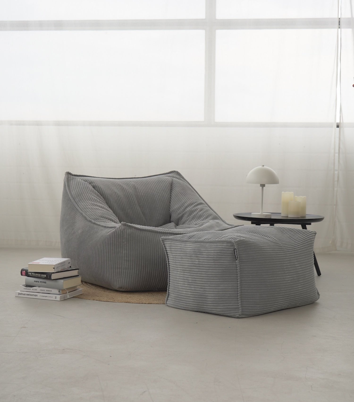 Produktvideo Sitzsack Sitzsessel 'Der Lümmel' aus Cord in grau. Mann setzt sich mit einer Tasse auf den Sitzsack, liest ein Buch, streicht über den Stoff und steht vom Sitzsack auf. 